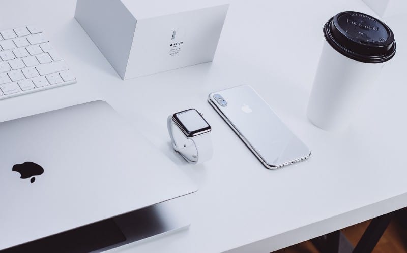 White table with watch, phone and laptop