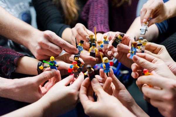 People holding small Lego characters