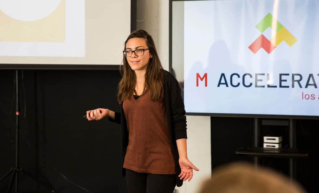 a woman standing in front of a projection screen - become certified facilitator