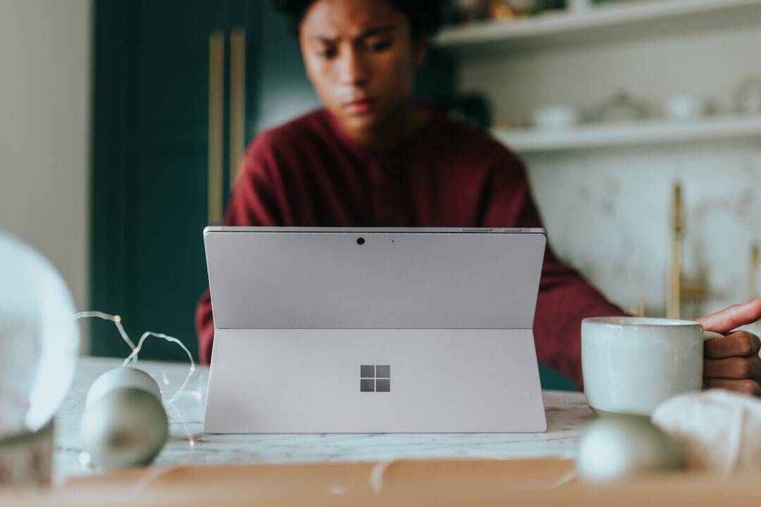 Man on his Surface laptop at home with Christmas decorations around - microsoft certified ai transformation leader