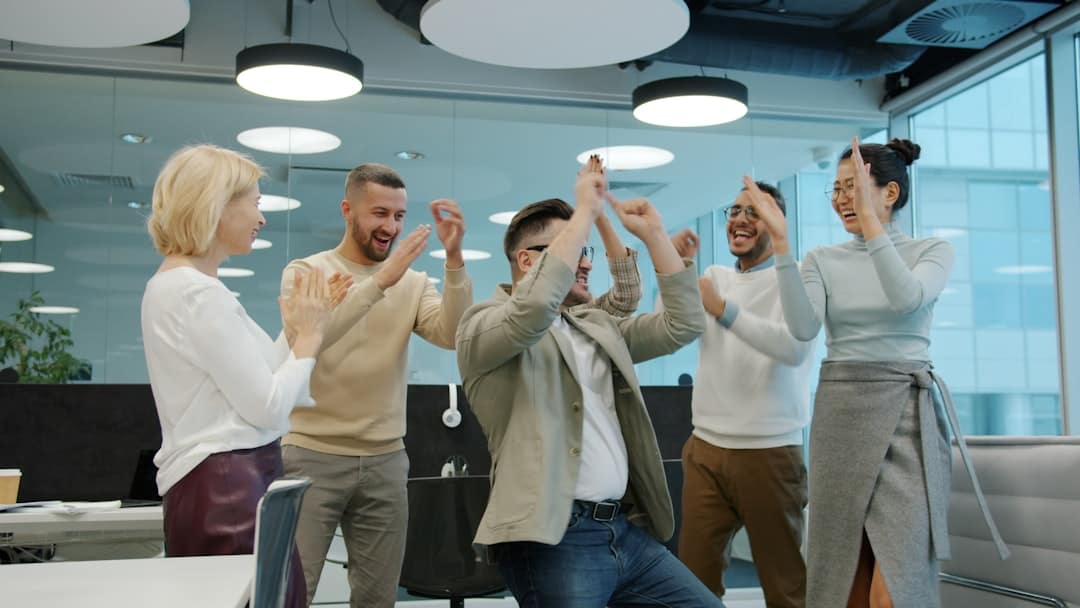 Diverse group of colleagues celebrating success in office - ai transformation playbook