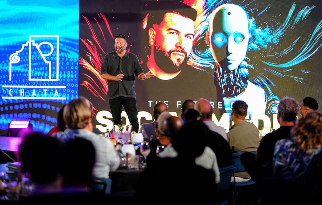 Man presents on stage with robot graphic background - ai business transformation