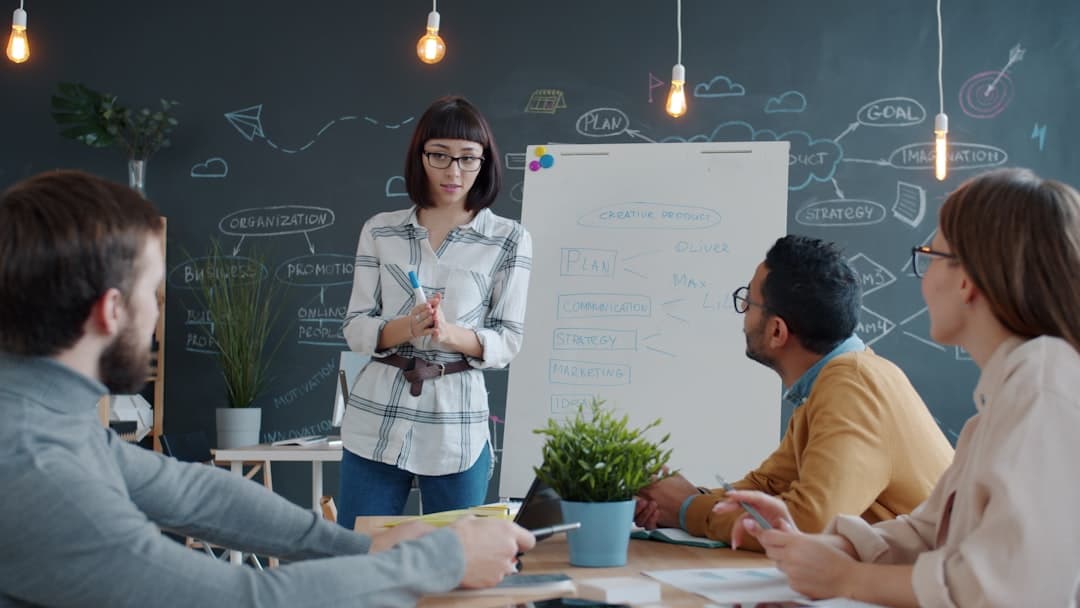 Woman presents to colleagues at a whiteboard meeting. - ai transformation strategy