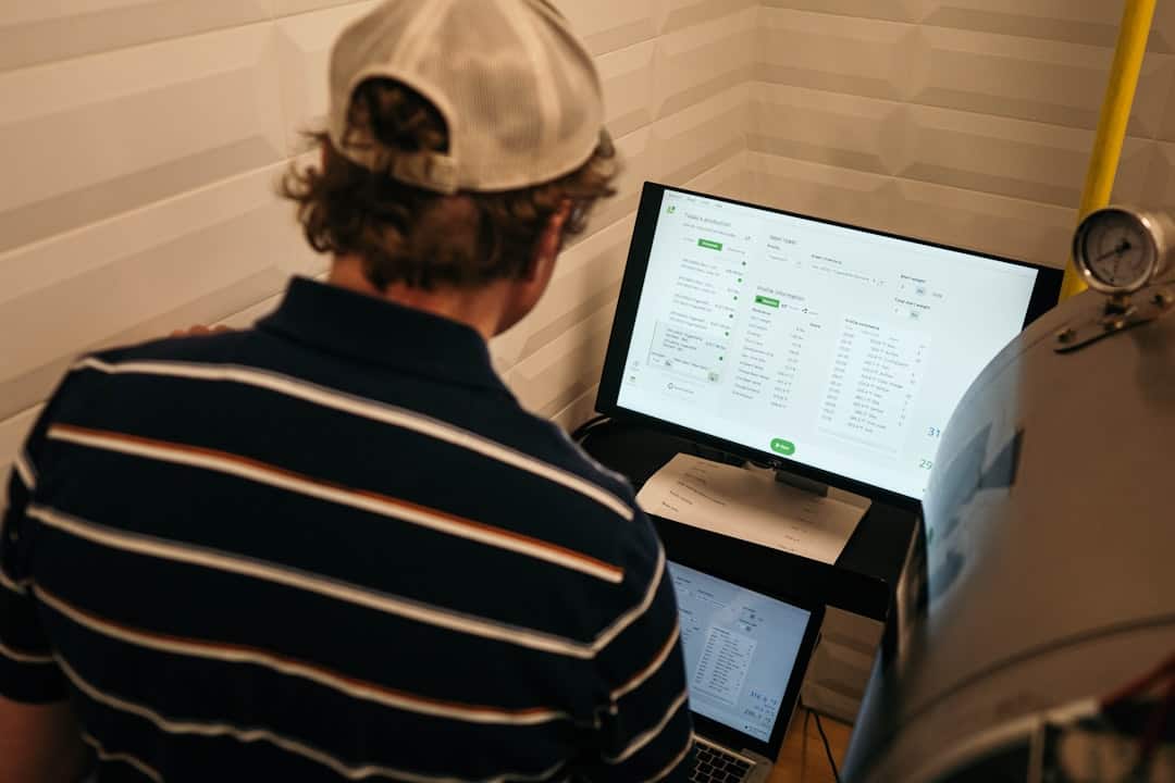 man in white and black striped polo shirt in front of monitor - ai roi measurement