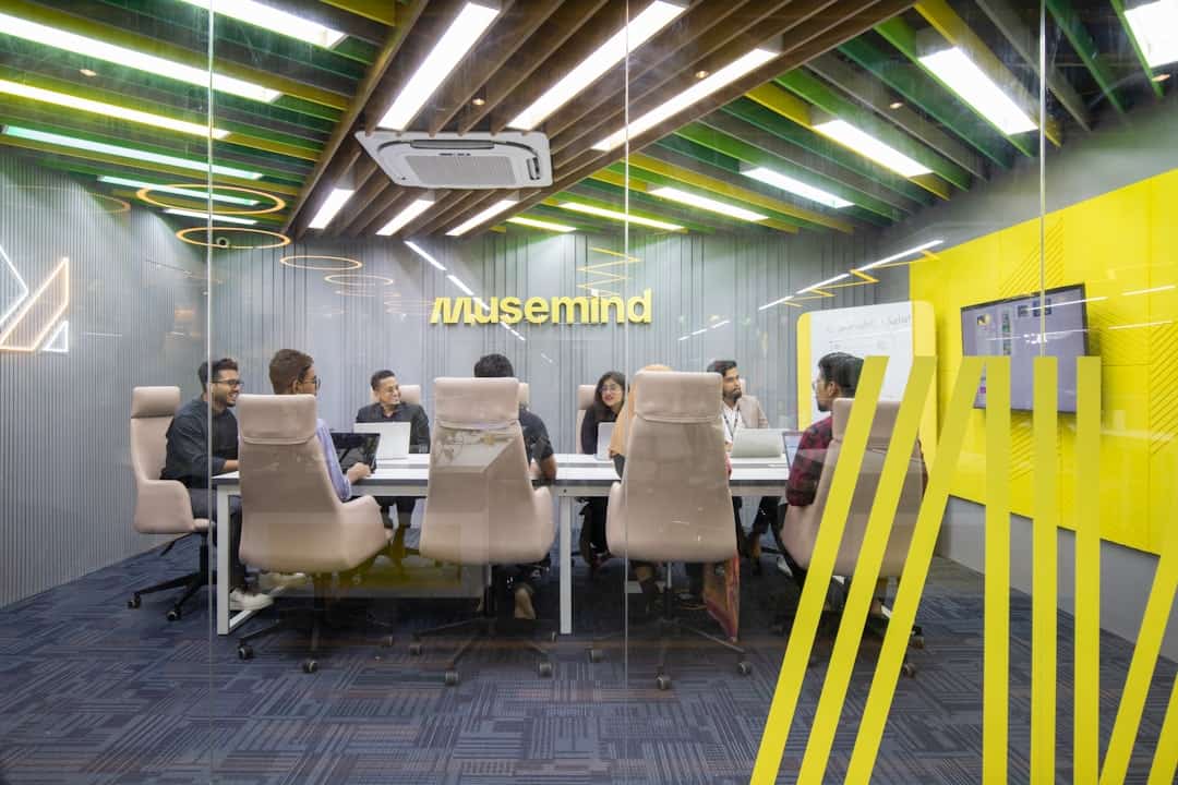 a group of people sitting around a table - ai transformation middle management buy-in