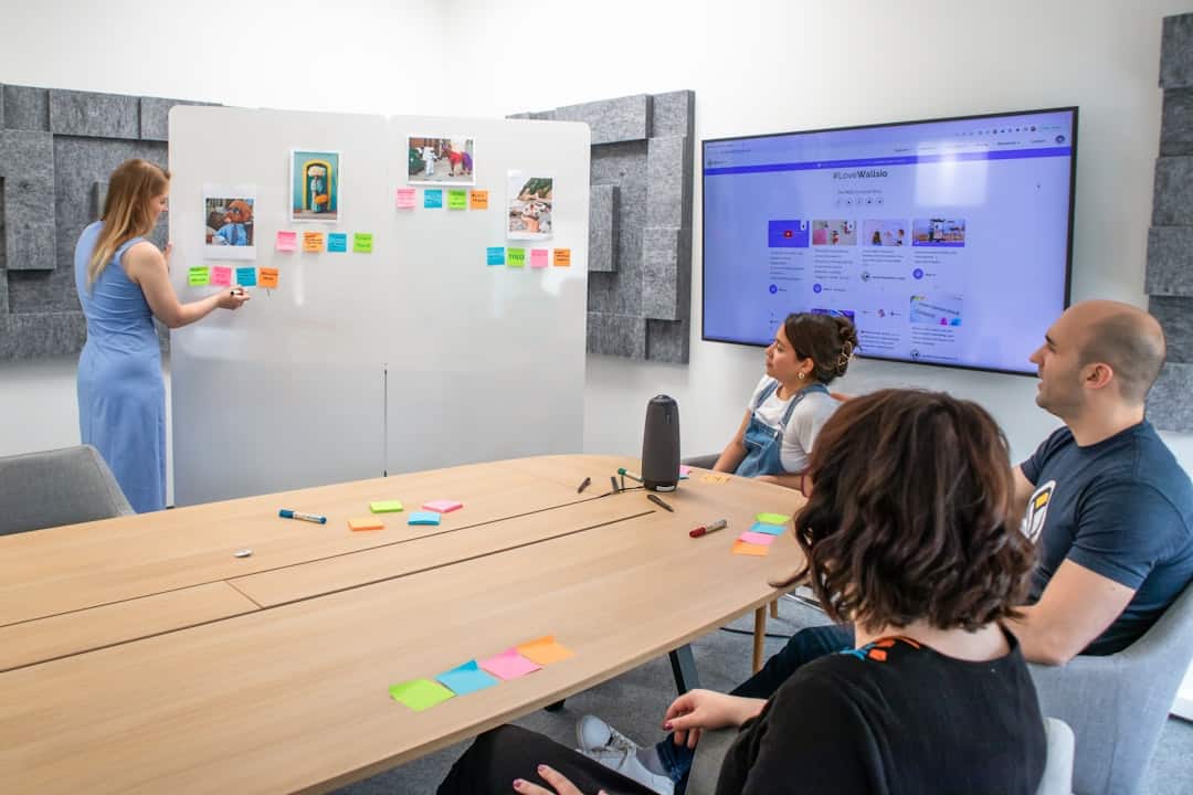 a group of people sitting around a conference table - design thinking ai era