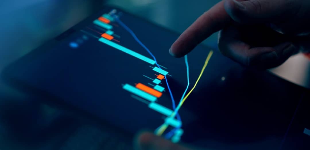 Fingers interacting with a stock market graph on a tablet - AI investment strategy