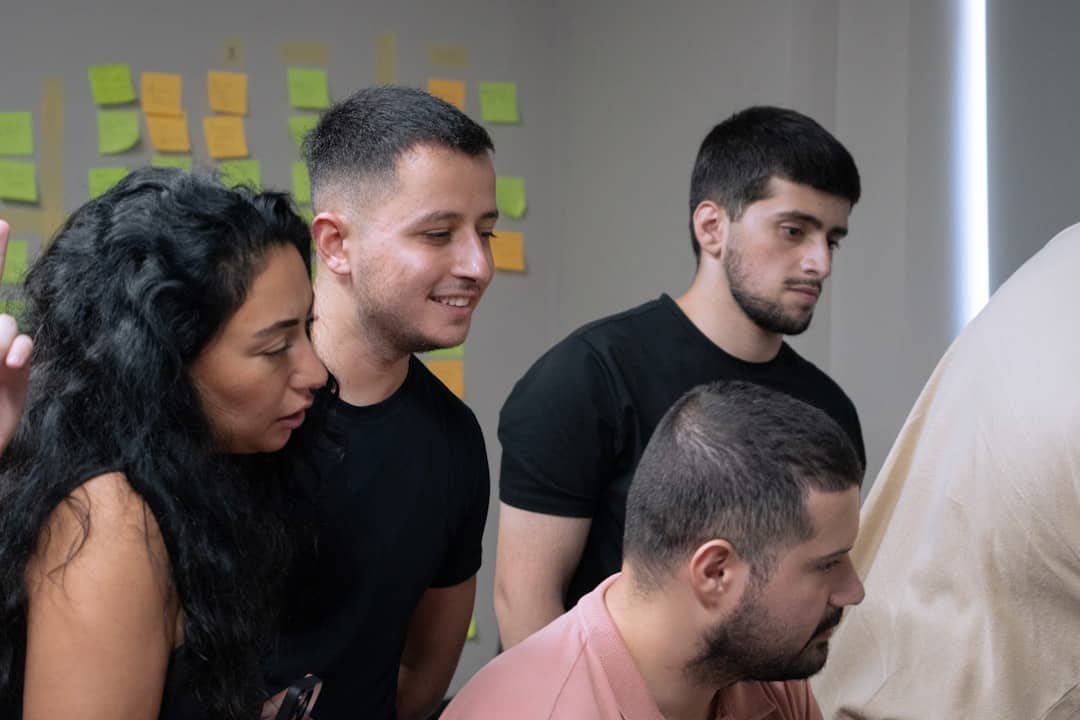 A group of people looking at a computer screen - team alignment ai